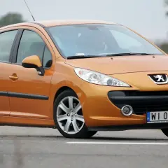 Pomarańczowy Peugeot 207 1.6 HDi na drodze.