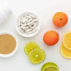 Biała butelka, miseczki z proszkiem i kapsułkami, pomarańcze, cytryny i limonki. Naturalne źródło hesperydyny.