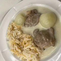 En tallrik med ris, köttbitar i en krämig sås och två hela kokta lökar. En riktig laban emo-måltid!