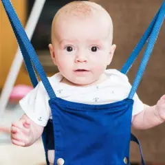 Uśmiechnięty bobas w niebieskim skoczku dla dzieci, wspierający rozwój ruchowy i fizjoterapię.
