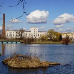 Nad jeziorem w Kazimierzu Wielkim, z ceglanym kominem i wieżą, rozciąga się kompleks budynków. Atrakcje tego miejsca przyciągają wzrok.