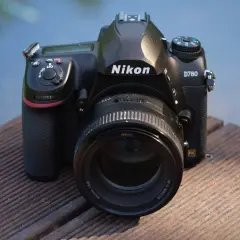 Nikon D780 z obiektywem 85mm f/1.8G na drewnianym pomoście. Aparat gotowy do testów.