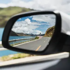 Speglar en vacker väg längs en sjö, perfekt för en roadtrip Europa.