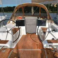 Il ponte di uno yacht con due timoni, un tendalino e un boccaporto, pronto per la navigazione.