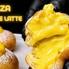 Bomboloni alla crema, soffici e ripieni, senza burro e latte. Un dolce invitante, pronto per essere gustato.