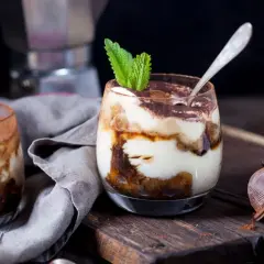 Pyszne tiramisu z mascarpone w pucharkach, udekorowane miętą i kakao. Idealny sprawdzony przepis na deser.
