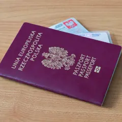 Polski paszport i dowód osobisty leżą na drewnianym stole. Czy na Wyspy Kanaryjskie potrzebny jest paszport? Tak, jeśli nie podróżujesz na dowód.