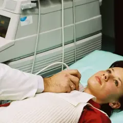 Lekarz wykonuje USG szyi pacjentce. Dostęp do opieki medycznej, w tym badań, jest ważny, nawet gdy szukasz pracy i masz ubezpieczenie zdrowotne dla bezrobotnych.