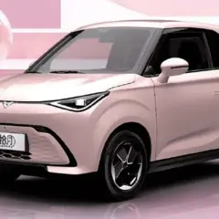 Un'elegante auto elettrica cinese color rosa pastello, con un design moderno e compatto, pronta a conquistare le strade.