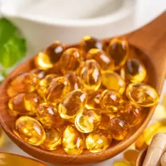 Łyżka pełna kapsułek z omega 3. Kwasy te wspierają serce, mózg i wzrok.