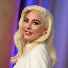 Lady Gaga med blont hår och vit klänning, ser ut som en stjärna som kan ha barn.