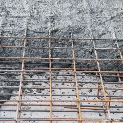 Siatka zbrojeniowa czeka na beton. Jaki beton na chudziaka będzie najlepszy? Ten szary, mokry materiał wygląda obiecująco.