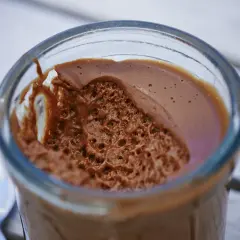 Une délicieuse mousse au chocolat à tomber par terre, servie dans un verre, avec une texture aérienne et gourmande.
