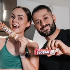 Ein glückliches Paar hält proteinriegel vor dem sport. Sie sind bereit für ihr Training mit EVOBAR.