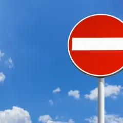 Panneau sens interdit rouge et blanc sous un ciel bleu avec des nuages. Combien de points pour un sens interdit ? Zéro, c'est une interdiction !
