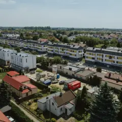 Nowe bloki mieszkalne w budowie, otoczone starszą zabudową i zielenią. To obraz rozwoju tej największej dzielnicy Warszawy.