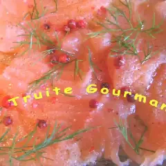 Carpaccio de truite finement tranché, parsemé de baies roses et d'aneth frais. Un délice gourmand.