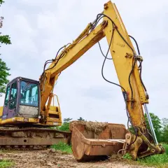 Żółta koparka gąsienicowa na placu budowy. Zastanawiasz się, jaki olej hydrauliczny do koparki będzie najlepszy?