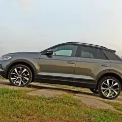 Szary VW T-Roc na tle jesiennego krajobrazu. Poznaj jego wymiary i możliwości terenowe.