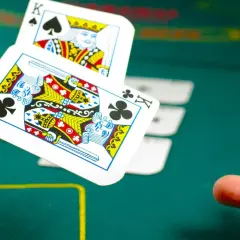 Dwa króle w powietrzu, jeden pik, drugi karo. W tle żetony i zielony stół do gry. Wspaniałe kolory kart.