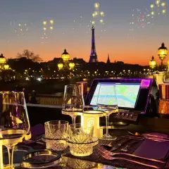 Vue sur Paris au crépuscule, avec la Tour Eiffel illuminée. Une table dressée pour un dîner romantique, parfaite pour savoir où manger après minuit.