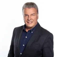 Uśmiechnięty Emilian Kamiński w granatowej marynarce i koszuli.