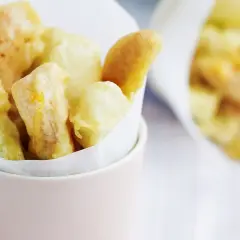Verdure croccanti immerse in una leggera pastella per verdure fritte, servite in un contenitore rosa.