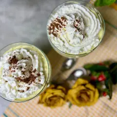 Dwa pucharki z kremem mascarpone, udekorowane bitą śmietaną i kakao. Idealne, gdy zastanawiasz się, co zrobić z mascarpone.