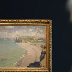 Obraz przedstawia malowniczą plażę w Pourville, z klifami i morzem w tle.