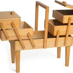 Un costurero madera grande con múltiples compartimentos y patas, ideal para organizar hilos, agujas y otros accesorios de costura.