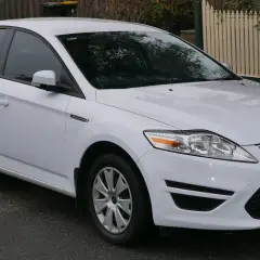 Biały Ford Mondeo MK4, często chwalony w opiniach za komfort i przestronność, zaparkowany na ulicy.
