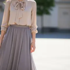 Elegancka beżowa bluzka z kokardą i szara, zwiewna bluzka do długiej spódnicy.