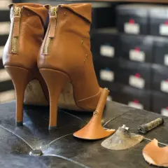 Bottes à talons aiguilles marron avec talons cassés, prêtes à réparer chaussures.