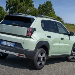 Jasnozielony Fiat Panda, jeden z najlepszych hatchbacków, na tle zielonych wzgórz.