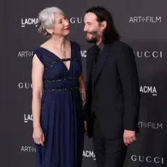 Alexandra Grant wzrost jest widoczny obok Keanu Reevesa. Oboje pozują na tle logo Gucci i Art+Film.