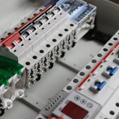 Nowe zabezpieczenia elektryczne, w tym wyłącznik różnicowoprądowy, gotowe do montażu w rozdzielnicy.