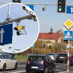 Kamery na skrzyżowaniach rejestrują wykroczenia. Widok na ruchliwe skrzyżowanie z sygnalizacją świetlną i znakami drogowymi.