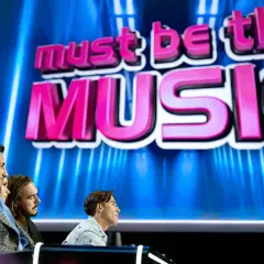 Trzech jurorów siedzi przed ekranem z napisem "must be the MUSIC".