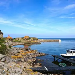 Kamienna wieża i domki na skalistej wysepce nad spokojnym Bałtykiem. Ile wysp jest na Bałtyku? Tyle, ile potrzeba, by poczuć spokój.
