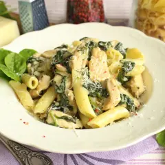 Penne z kurczakiem i szpinakiem w kremowym sosie, posypane parmezanem. Pyszne danie, które zachwyci każdego.