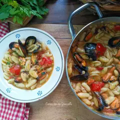 Un piatto invitante di cavatelli cozze e fagioli, con pomodorini e prezzemolo fresco. Un sapore di mare e terra.