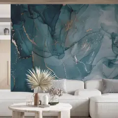 Ein Wohnzimmer mit einem Sofa und einem Couchtisch, das durch eine atemberaubende Wand mit Marmoroptik und goldenen Akzenten als wandfarbe akzente aufgewertet wird.