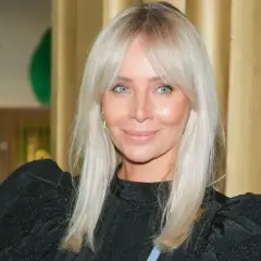 Blondynka z błękitnymi oczami i subtelnym cieniowaniem grzywki, uśmiecha się do obiektywu.