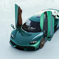 Zielony Koenigsegg 4 osobowy z otwartymi drzwiami, prezentujący luksusowe wnętrze i sportowy design.