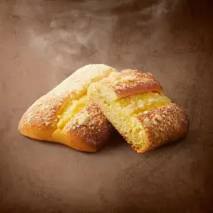 Dwie drożdżówki z budyniem i kruszonką na brązowym tle.