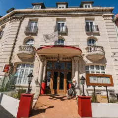Façade de l'hôtel Majestic à Châtelaillon-Plage avec son entrée principale en bois et un drapeau blanc.