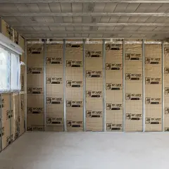Intérieur d'une maison en construction, murs recouverts d'isolant pour limiter la déperdition chaleur maison. Fenêtre avec volet roulant.