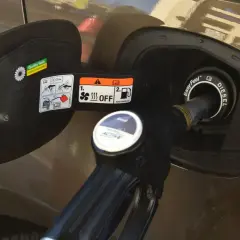 Dozbrań do baku diesla. Pistolet paliwowy wlewa paliwo do samochodu, pokazując, jak zatankować auto.