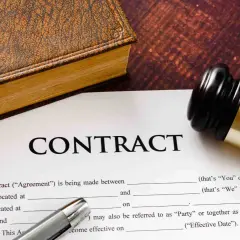 Un contrat, un livre ancien et un maillet de juge. Un exemple de lettre de fin de mission pour un contrat.