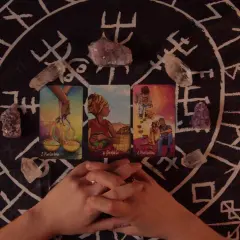 Horoskop miesięczny Lew Tarot: karty i kryształy na tle runicznym.